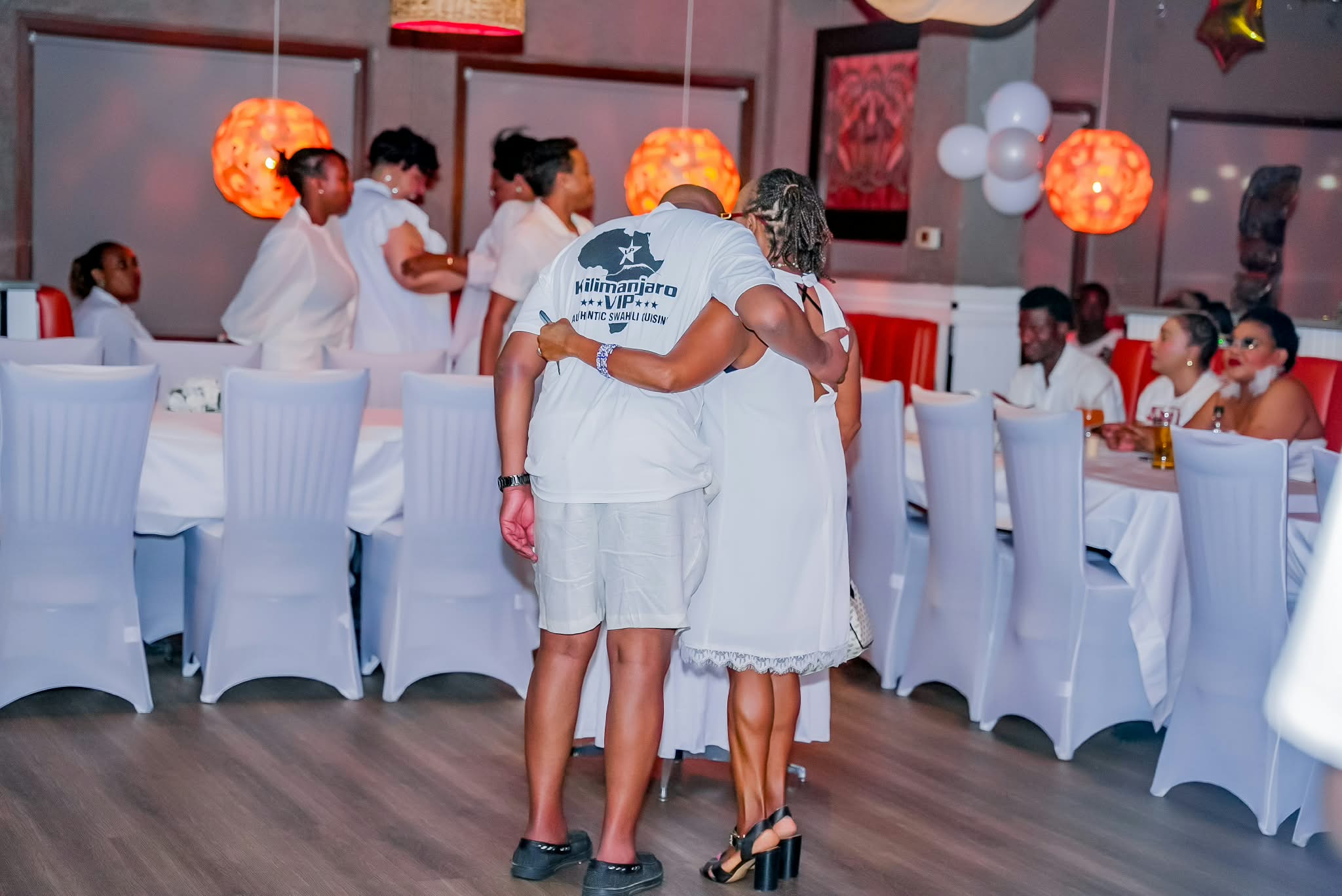 Guests in all-white attire celebrating in the Kilimanjaro VIP dining room