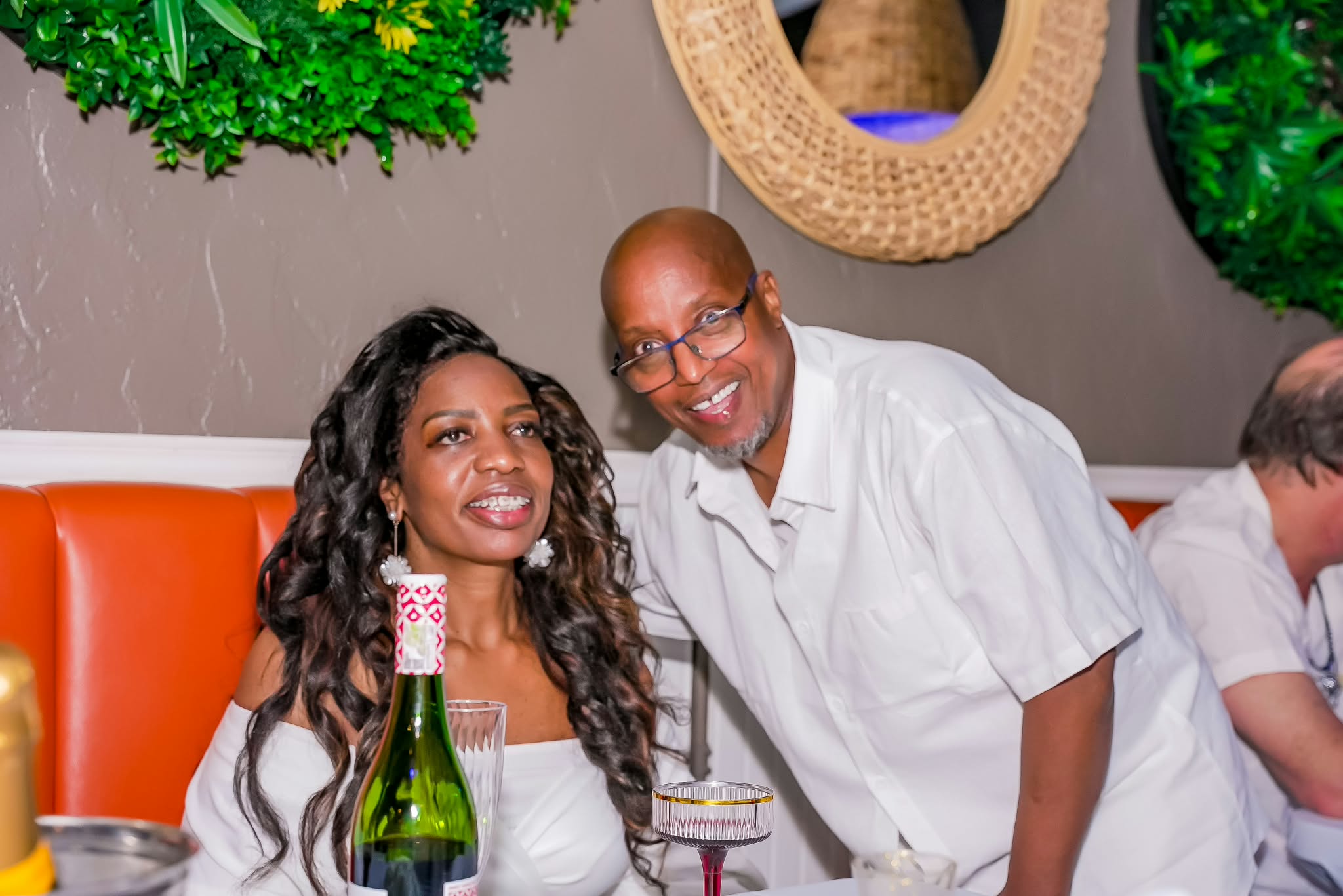 Guests relaxing together in an orange booth
